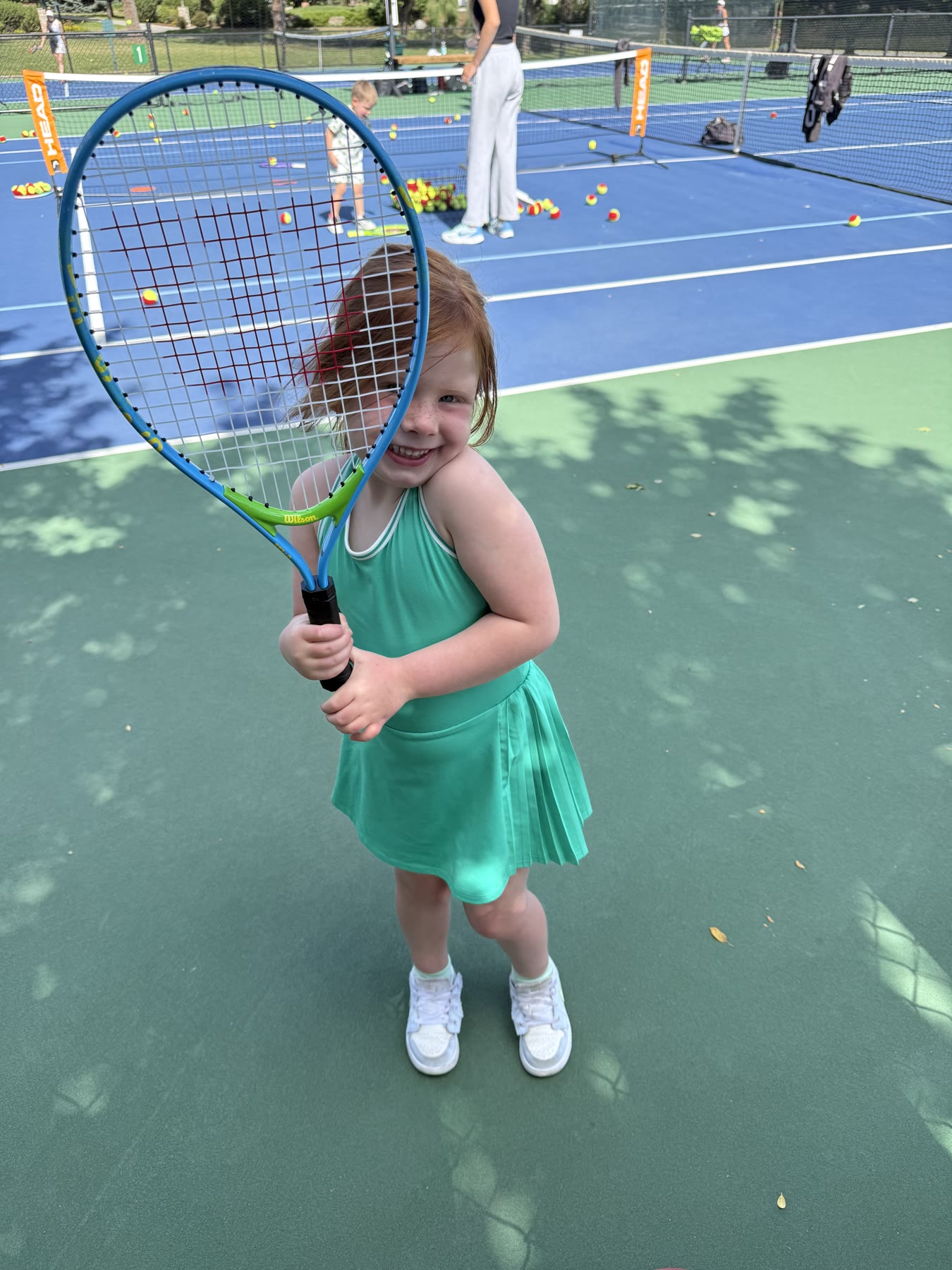Gracie Jennings smiling with a tennis racket on the court